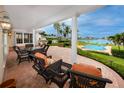 Covered patio with wicker furniture, columns, outdoor grill, and views of the pool and waterway at 224 Harbor View Ln, Largo, FL 33770