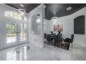 Dining room featuring marble tiled floors, a modern chandelier, and a glass dining table at 27528 Water Ash Dr, Wesley Chapel, FL 33544