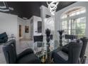 Dining room with glass top table, black leather chairs, and modern chandelier lighting at 27528 Water Ash Dr, Wesley Chapel, FL 33544