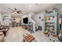 View of the living room featuring tile flooring, a ceiling fan, and an entertainment center at 2844 Jacob Crossing Ln, Holiday, FL 34691