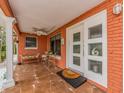 Welcoming front porch featuring tiled flooring, ample seating, and a decorative front door for a cozy entry at 308 Cedar Ln, Largo, FL 33770