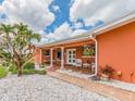 Inviting front porch with a tiled walkway, cozy seating, and vibrant plants adds curb appeal to this home at 308 Cedar Ln, Largo, FL 33770