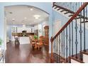 Open-concept dining area with wood floors, flowing into kitchen, with staircase in view at 3503 W Price Ave, Tampa, FL 33611