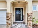 Close up of stylish front door with stone accents and 'Welcome Home' wreath at 3503 W Price Ave, Tampa, FL 33611