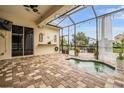 Relaxing screened-in patio with brick flooring, hot tub, and outdoor seating area at 4400 English Turn Way, Wesley Chapel, FL 33543