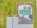 Aerial view featuring a screened-in pool and well-maintained roof of the home at 4419 Gaston St, Spring Hill, FL 34607