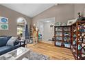 Cozy living room with vaulted ceilings, wood floors and an arched window with natural light at 4419 Gaston St, Spring Hill, FL 34607