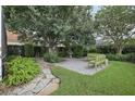 Lush backyard featuring a stone patio, mature trees, and comfortable seating for outdoor relaxation at 4926 Pennecott Way, Wesley Chapel, FL 33544