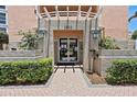 Building entrance with well-manicured landscaping and brick walkway at 4953 Bacopa S Ln # 205, St Petersburg, FL 33715
