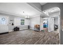 Open-concept living room with wood-look floors, grey walls, and a view to the doorway at 538 Bamboo Ln, Clearwater, FL 33764