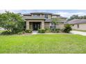 Beautiful home boasts lush green lawn, mature trees, and manicured landscaping for great curb appeal at 5931 Cherry Oak Dr, Valrico, FL 33596