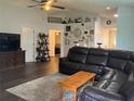 Spacious living room with dark wood flooring, a large sectional couch, and wall decor at 6905 Summer Harbor Ln, Riverview, FL 33578