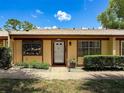 Inviting single story home features a well maintained lawn, beautiful shrubs, and neutral color scheme at 8320 High Point Cir # 5, Port Richey, FL 34668