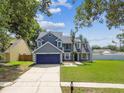 Charming two-story home with a well-manicured lawn and mature trees at 10208 Evening Trail Dr, Riverview, FL 33569