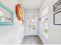 Neutral entryway with unique wall decor, white door with glass accents, and wood-look tile at 10669 Cardera Dr, Riverview, FL 33578