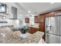 A modern kitchen featuring granite countertops, stainless appliances, and decorative fixtures at 11245 Bella Loma Dr, Largo, FL 33774