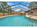 Enjoy a private backyard oasis featuring a screened in pool and wooden privacy fence at 11245 Bella Loma Dr, Largo, FL 33774