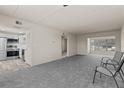 Open-concept living room featuring new carpet and view of kitchen with stainless steel appliances at 11620 Park Blvd # 306, Seminole, FL 33772