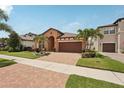 Attractive single-story home with a brick driveway, complemented by palm trees and a manicured lawn at 13128 Foxtail Fern Dr, Riverview, FL 33579
