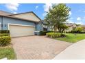 Charming single-Gathering home boasts a brick driveway, two-car garage, and lush landscaping at 16898 Balance Cv, Land O Lakes, FL 34638