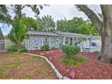 Charming home with a manicured front yard, garden beds, and decorative patriotic accents at 215 Claire Dr, Seffner, FL 33584