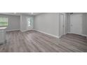Open living room with wood-look floors, neutral paint, and lots of natural light at 2307 N 47Th St, Tampa, FL 33605
