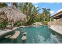 Tropical pool area featuring a tiki hut and bar stools within the refreshing pool at 307 Palmetto Ln, Largo, FL 33770