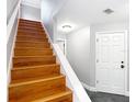 Wooden stairs with a white railing leading to an upper level, next to a white entry door at 3111 W De Leon St # 2, Tampa, FL 33609