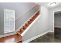 A wood staircase featuring a white railing and a window providing ample natural light at 3111 W De Leon St # 2, Tampa, FL 33609