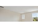Bright and airy carpeted bedroom with a neutral color palette and two large windows overlooking the neighborhood at 3483 Yellow Leaf Cir, Spring Hill, FL 34609