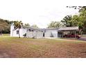 A single-story home with a white exterior, complemented by a lush green lawn at 38819 Otis Allen Rd, Zephyrhills, FL 33540