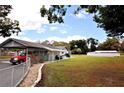 Sprawling front lawn and a single-story home featuring an attached carport and long driveway at 38819 Otis Allen Rd, Zephyrhills, FL 33540