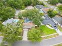 An aerial view of a neighborhood with tree-lined streets, pools, and well-maintained yards at 4509 Grainary Ave, Tampa, FL 33624