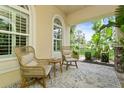 Inviting patio with comfortable wicker furniture and views of the well-manicured lawn at 4973 Antiquity Way, Sarasota, FL 34240