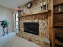 Close up of stone fireplace with mantle, decorative accents, and view of the adjacent living area at 5004 Grainary Ave, Tampa, FL 33624