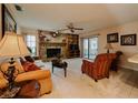 Inviting living room featuring a cozy stone fireplace, neutral carpet, and sliding glass doors leading to the patio at 5004 Grainary Ave, Tampa, FL 33624