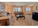 Comfortable living room showcasing plush sofas, a glass-top coffee table, and sunlit windows with elegant curtains at 5004 Grainary Ave, Tampa, FL 33624