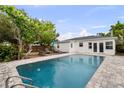 Backyard oasis featuring a beautiful pool with brick pavers, lush landscaping, and lounge chairs for relaxing at 549 39Th Ne Ave, St Petersburg, FL 33703