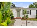 Inviting front porch with a brick landing, updated door and a lush, tropical landscaped yard at 549 39Th Ne Ave, St Petersburg, FL 33703