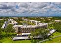 Aerial view of condo building overlooking lake, lush greenery and covered parking at 6190 80Th N St # 310, St Petersburg, FL 33709