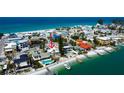 Coastal neighborhood aerial showing homes with private beaches, boat docks, and swimming pools on a sunny day at 7777 Bayshore Dr, Treasure Island, FL 33706