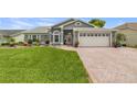 Inviting one-story home with lush green lawn, brick driveway, and a convenient two-car garage at 8441 Danbury Ln, Hudson, FL 34667