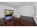 Bright living room featuring hardwood floors, high ceilings, and a sliding glass door to the backyard at 944 San Carlos Ne Ct, St Petersburg, FL 33702