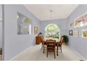 Cozy dining room featuring a round table, arched window, and neutral-toned carpet at 1051 Glynwood Pl, Dunedin, FL 34698