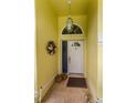Inviting entryway with a white front door, decorative wreath, and neutral-toned tile flooring at 1051 Glynwood Pl, Dunedin, FL 34698
