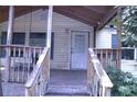 Entrance to a home with a covered front porch and a wooden railing at 10641 Atlee St, New Port Richey, FL 34654
