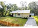 Quaint home with metal roof, tidy lawn and landscaping and concrete driveway to outbuilding at 10804 Bounty St, New Port Richey, FL 34654