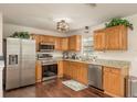 Well-lit kitchen featuring stainless steel appliances, granite countertops, and wooden cabinets at 10804 Bounty St, New Port Richey, FL 34654