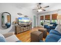 Inviting living room with hardwood floors, a plush blue sofa, and natural light streaming through window blinds at 111 29Th W St, Bradenton, FL 34205