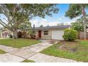 Attractive single-story home with red door, garage, and mature landscaping at 11320 125Th Ter, Largo, FL 33778